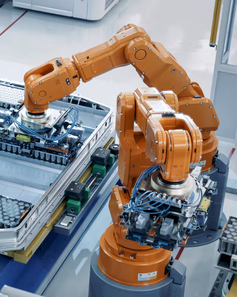 Industrieroboterarm in einer Fertigungsstraße mit automatischer Teilehandhabung.