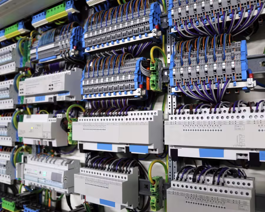 Nahaufnahme eines komplexen elektrischen Schaltschrankes mit vielen Kabeln und Schaltgeräten.