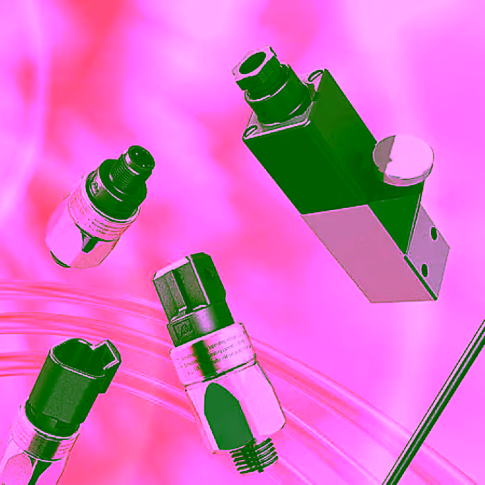 Mehrere mechanische Druckschalter verschiedener Bauarten vor rosa Hintergrund.